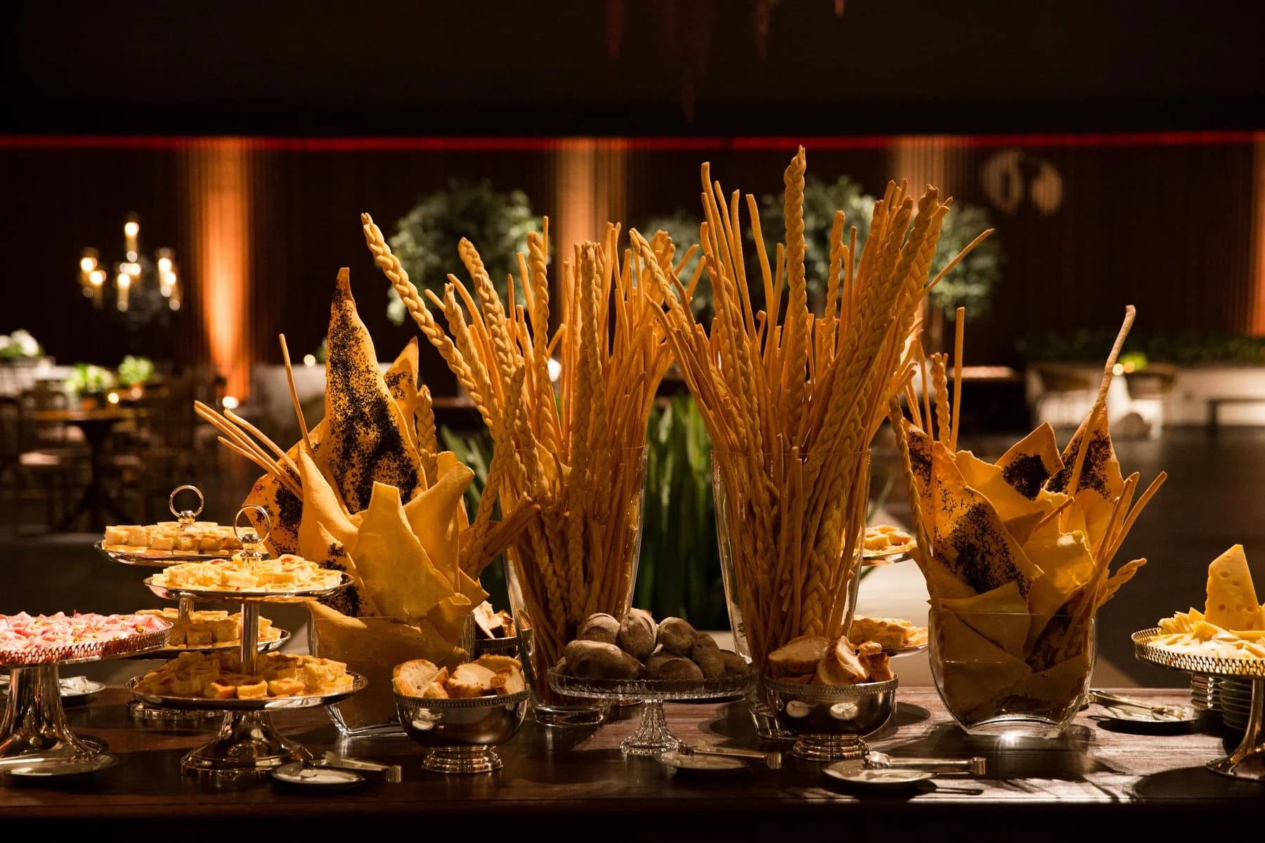 Mesa de buffet com pães artesanais, queijos e entradas em uma recepção